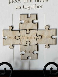 a wooden puzzle with words on it and four pieces missing from each piece that holds us together