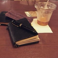 a cup of coffee and notebooks on a table