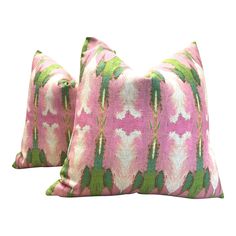 two pink and green pillows on white background