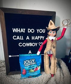 an elf is holding a sign that says, what do you call a happy cowboy?