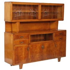 a large wooden cabinet with glass doors and drawers on the bottom, side by side