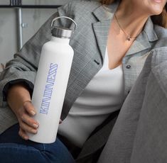 a woman sitting on a couch holding a water bottle