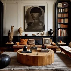 a living room filled with furniture and bookshelves next to a painting on the wall