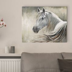 a painting of a white horse is hanging on the wall