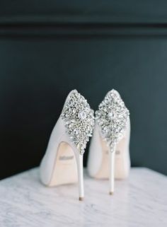 a pair of white high heel shoes sitting on top of a table