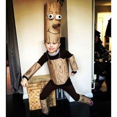 a young boy dressed up as a tree stump