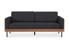 a black couch with wooden frame and dark fabric upholstered on the armrests