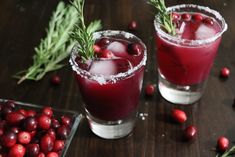 two glasses filled with cranberry juice and garnished with sprigs