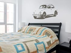 a bed room with a neatly made bed and a wall sticker on the wall