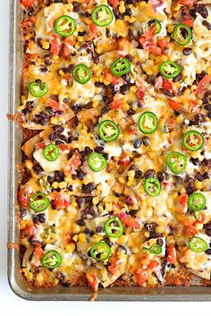 a square casserole dish with black beans, cheese and green peppers on top