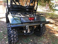 the rear end of a four - wheeler parked under a tree