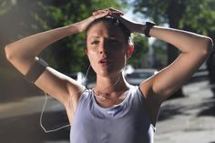 a woman is standing in the street with her hands on her head