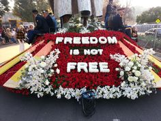 a large flower arrangement with the words freedom is not free written on it in white and red flowers