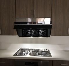 a stove top oven sitting inside of a kitchen next to wooden cabinets and cupboards