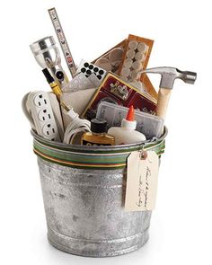 a metal bucket filled with lots of assorted items on top of a white surface