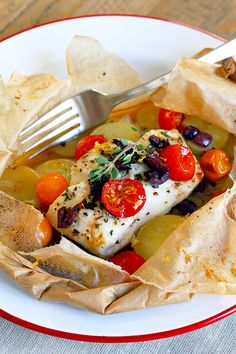 a white plate topped with fish and veggies next to tortilla chips