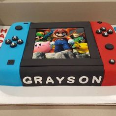 a birthday cake made to look like a nintendo wii game console with characters on it