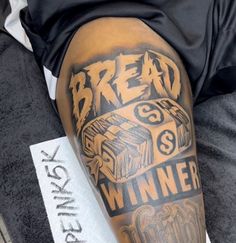 a man with a tattoo on his leg that says bread winner