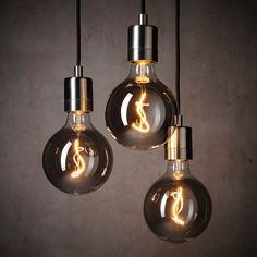 three light bulbs hanging from the ceiling with one bulb turned upside down and the other turned on