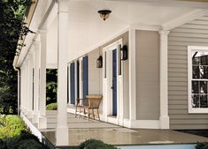 the front porch of a house with blue shutters