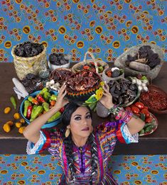 a woman in mexican attire holding her head above food