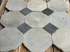 a wooden table topped with lots of gray and black tiles