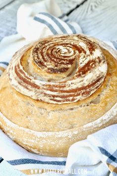 a round loaf of bread sitting on top of a blue and white towel