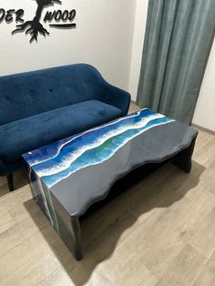 a blue couch sitting next to a table on top of a hard wood floor