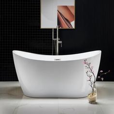 a white bath tub sitting in a bathroom next to a painting on the wall and a vase with flowers