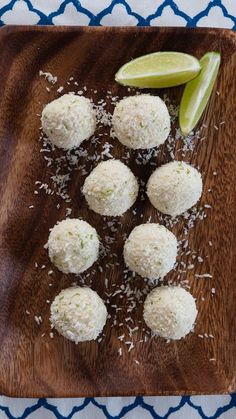 some food is sitting on a wooden cutting board with limes and salt next to it