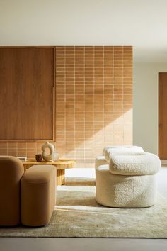 a living room with two couches and a table in the middle, next to a wooden paneled wall