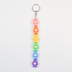 a rainbow colored key chain hanging on a white wall