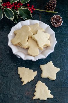 some cookies are on a white plate next to holly