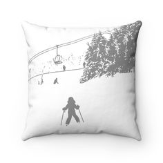 a black and white pillow with a skier going down the hill on skis in the background