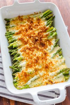 a casserole dish with cheese and asparagus in it on a table