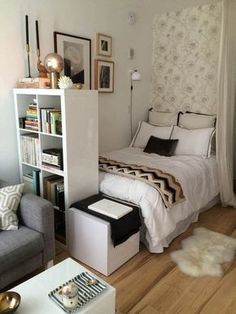 a small bedroom with a bed, couch and book shelf in the corner next to it