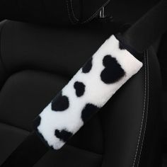 a black and white cow print seat belt cover