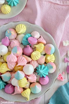 a white bowl filled with marshmallows on top of a pink table cloth