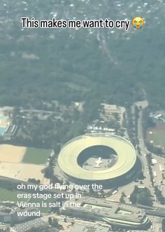 an aerial view of a large building in the middle of a city with words written below it