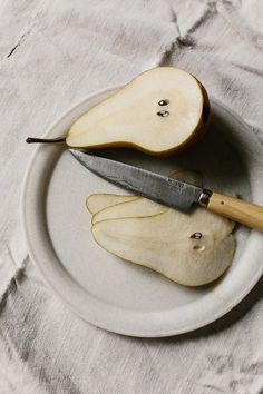 an apple sliced in half on a plate with a knife