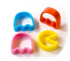 three plastic cookie cutters sitting next to each other on a white surface with the letters g and c