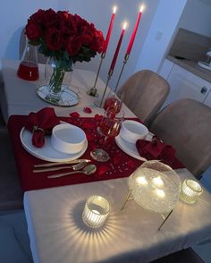 a table set for valentine's day with red roses and candles