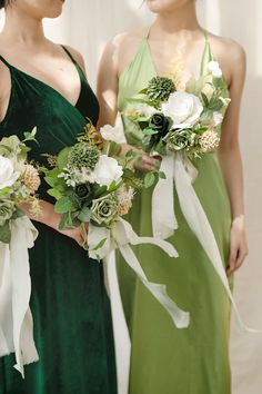 two bridesmaids in green dresses holding bouquets