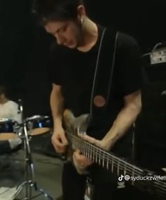 a man is playing an electric guitar in a recording studio