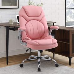 a pink office chair sitting on top of a wooden desk