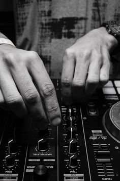 a dj mixing music on his turntable in front of the camera man's hands