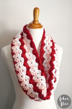 a red and white crocheted scarf on a mannequin