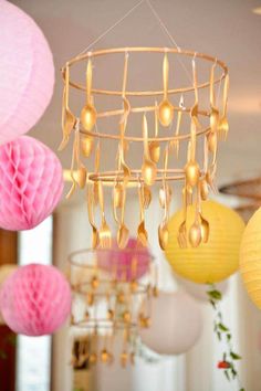 some paper lanterns hanging from the ceiling in a room with pink and yellow decorations on it