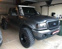 a truck parked in a garage next to two other trucks