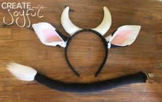 a wooden table topped with white horns and black headbands on top of it